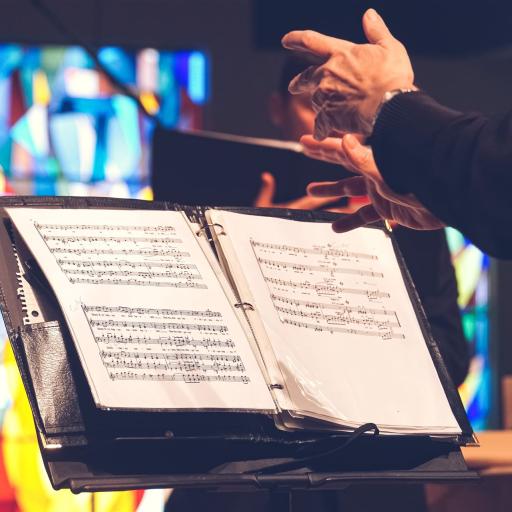 Conductors hands above sheet music sitting